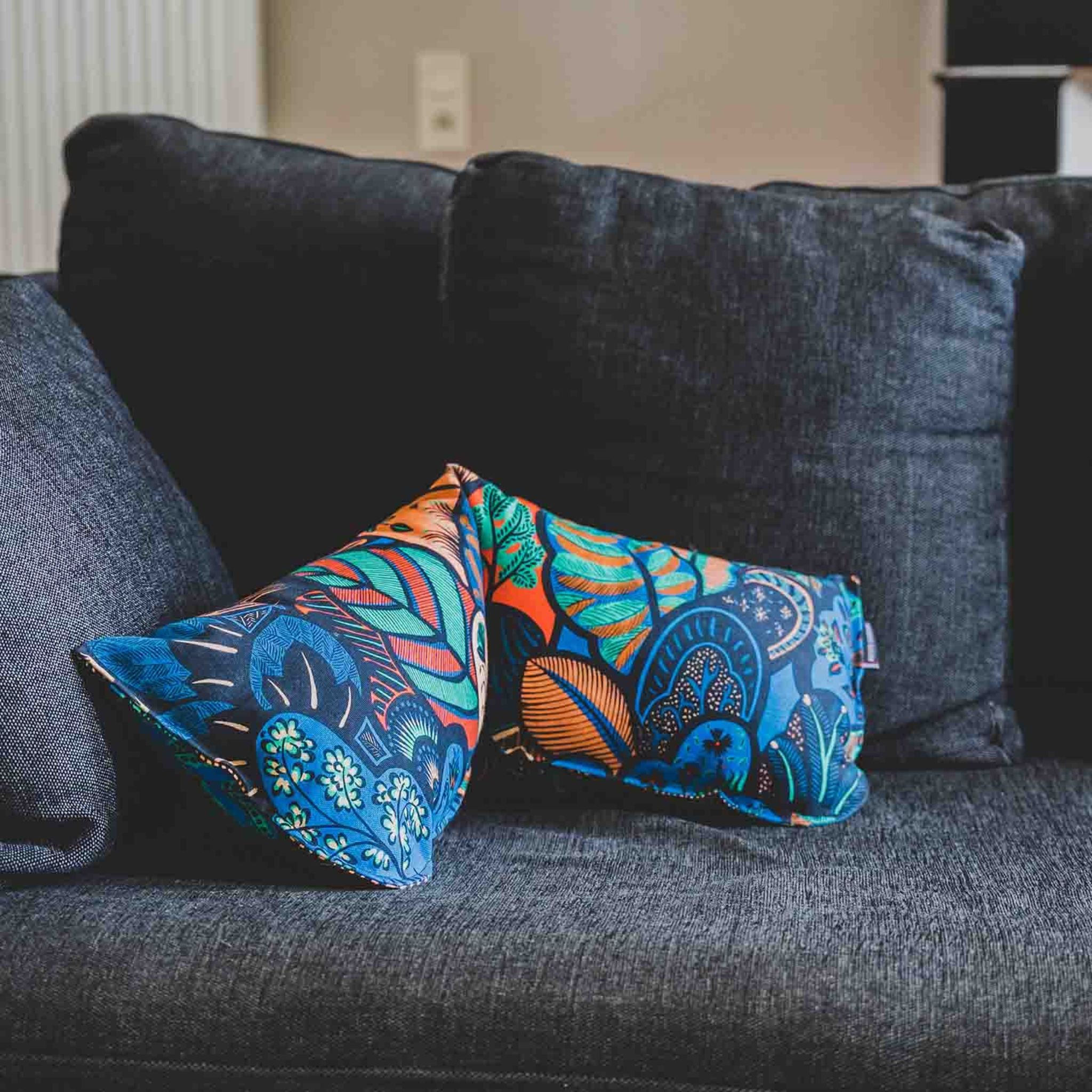 Coussin repose-tête Perséphone avec des couleurs vives et printanières et des motifs tropicaux. Un sublime coussin pratique et décoratif.