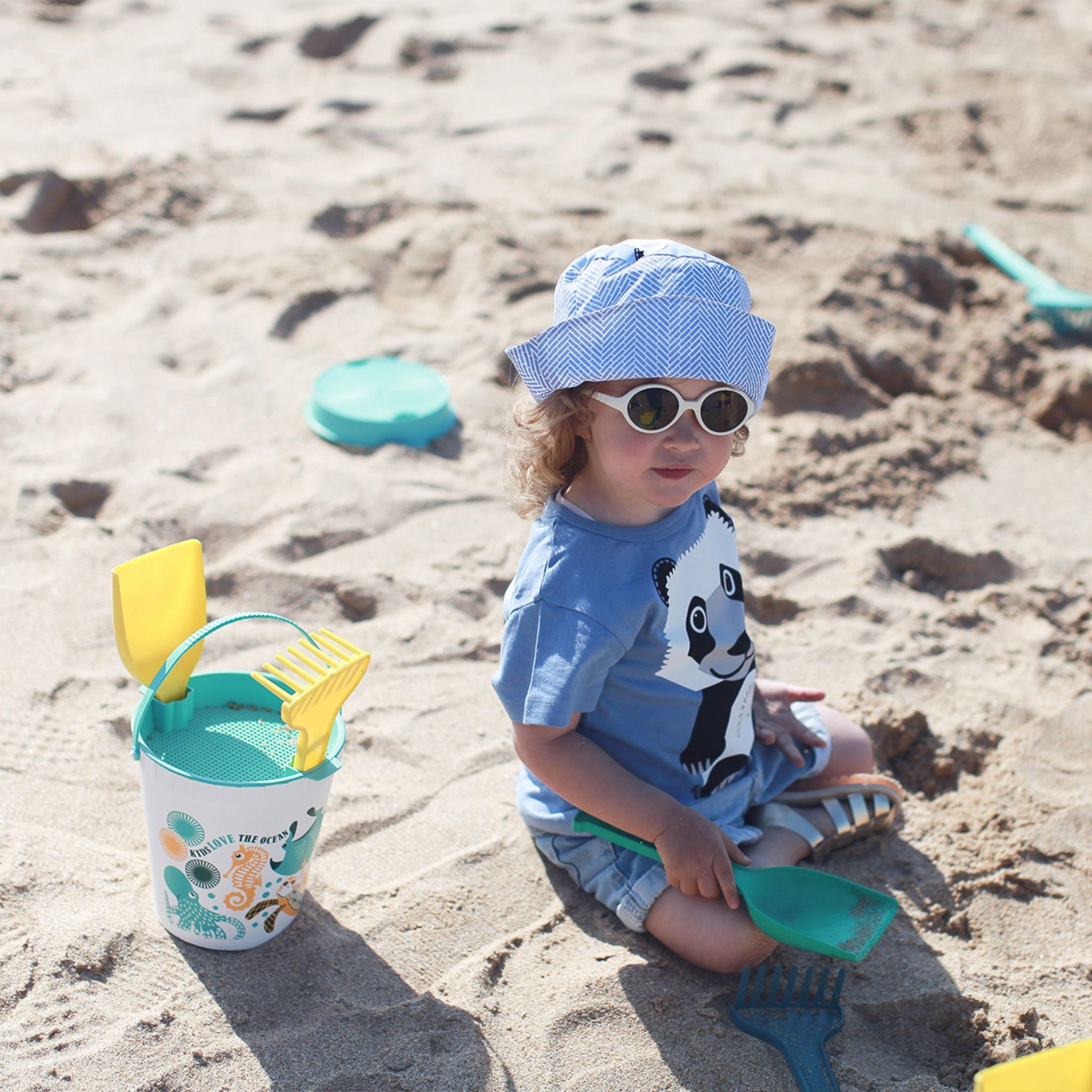 Enfant qui joue à la plage avec son set de plage