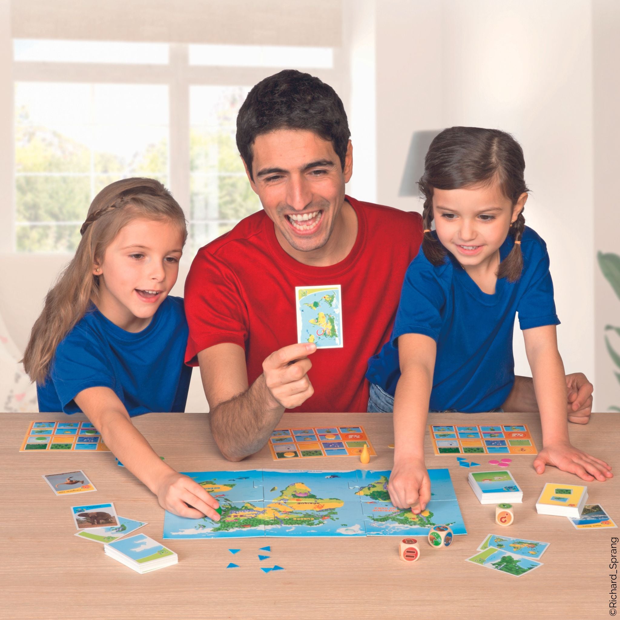 Enfants et papa qui jouent à Bioviva le jeu junior, un jeu de société ludique et pédagogique, fabriqué en France.